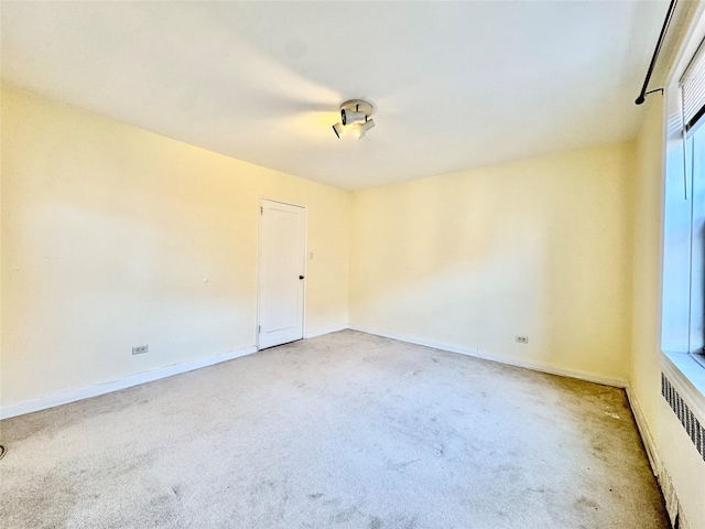 carpeted spare room featuring radiator heating unit