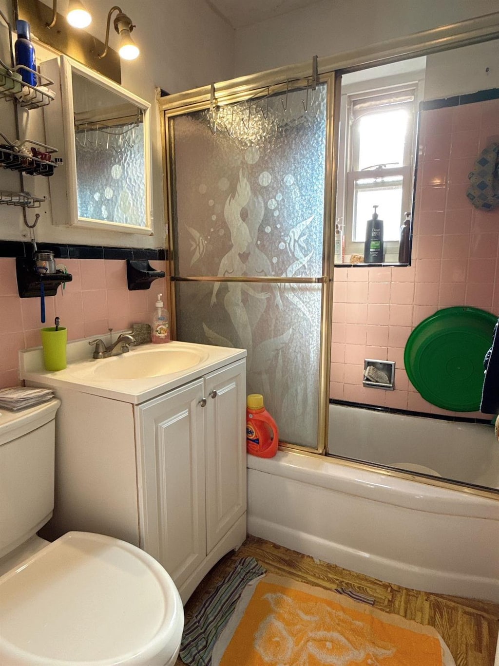 full bathroom with vanity, toilet, combined bath / shower with glass door, and tile walls