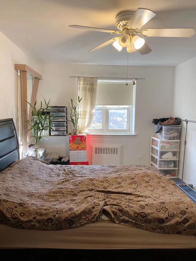 bedroom with ceiling fan and radiator heating unit