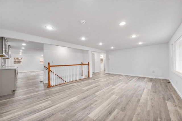 basement with light hardwood / wood-style flooring