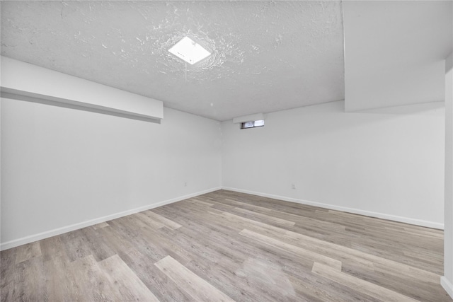 basement with a textured ceiling and light wood-type flooring