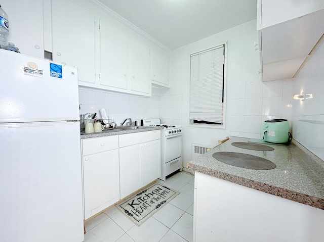 kitchen featuring sink, white cabinets, backsplash, white appliances, and light tile patterned floors