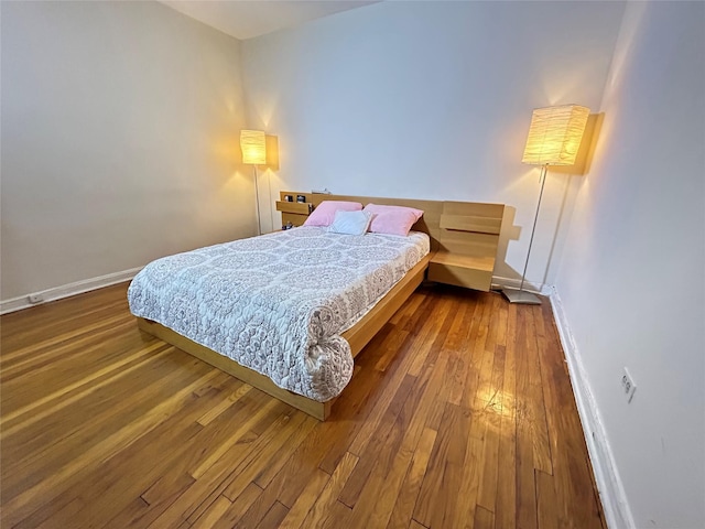 bedroom with dark hardwood / wood-style flooring