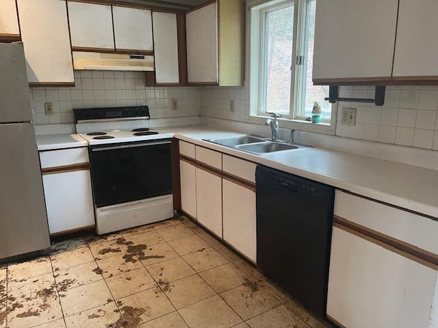 kitchen with stainless steel refrigerator, white cabinetry, black dishwasher, white electric range, and range hood