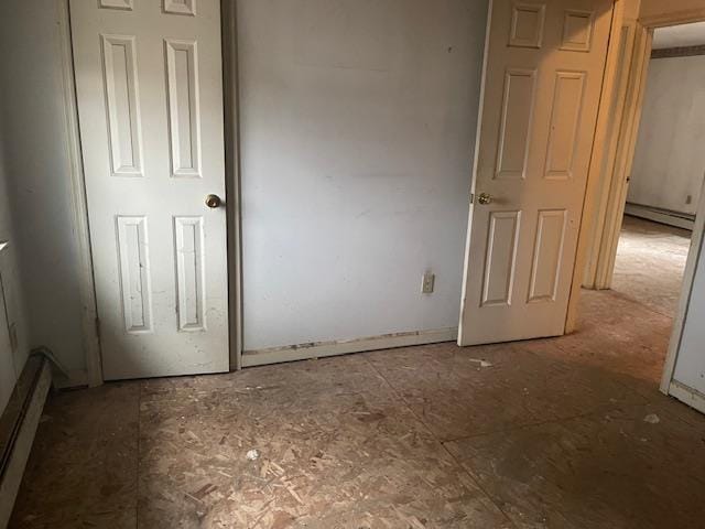 unfurnished bedroom featuring a baseboard heating unit