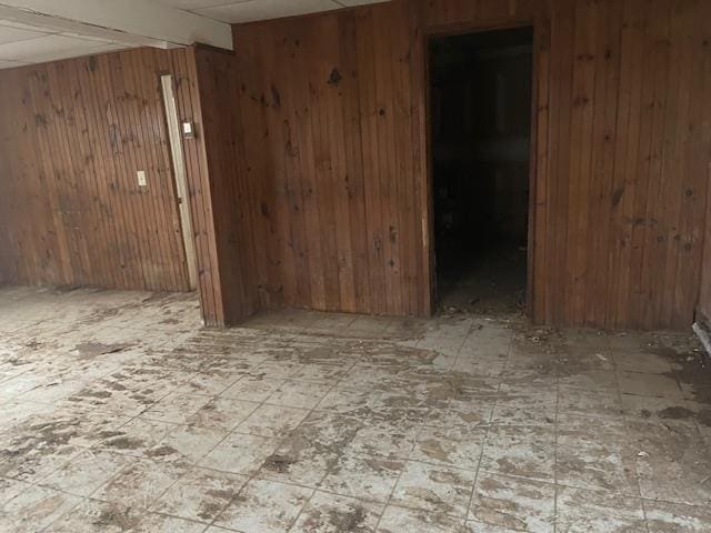 spare room with beam ceiling and wooden walls