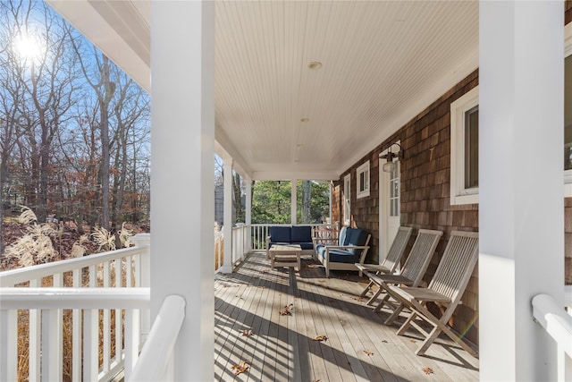 wooden deck with covered porch and an outdoor living space