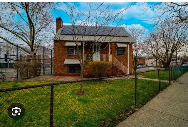 view of front of property featuring solar panels and a front yard