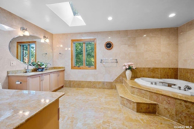 bathroom with a skylight, tile walls, and a healthy amount of sunlight