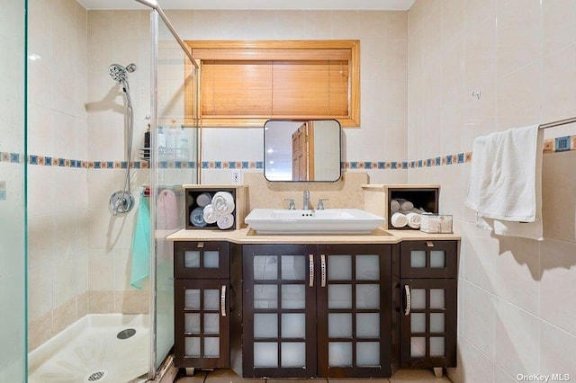 bathroom featuring an enclosed shower, sink, and tile walls