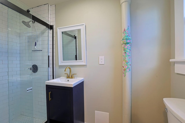 bathroom with vanity, a shower with shower door, and toilet