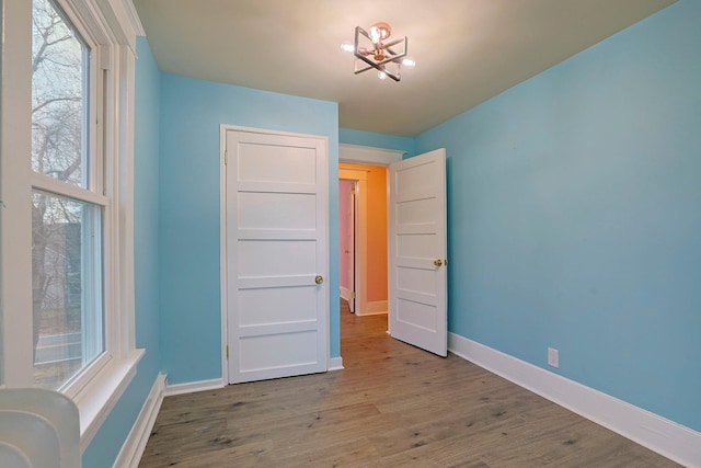 unfurnished bedroom featuring light hardwood / wood-style floors and an inviting chandelier