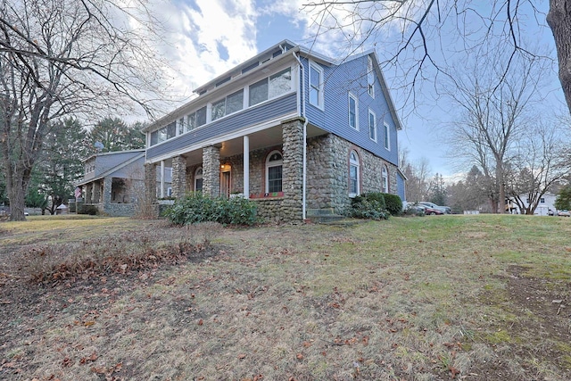 view of front of property featuring a front lawn and a sunroom