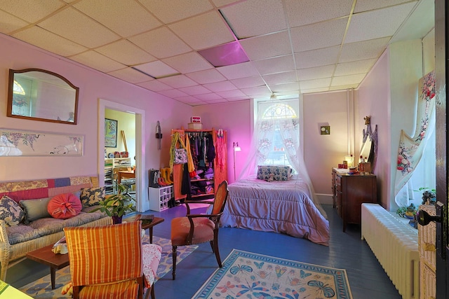 bedroom featuring a paneled ceiling, dark hardwood / wood-style floors, and radiator