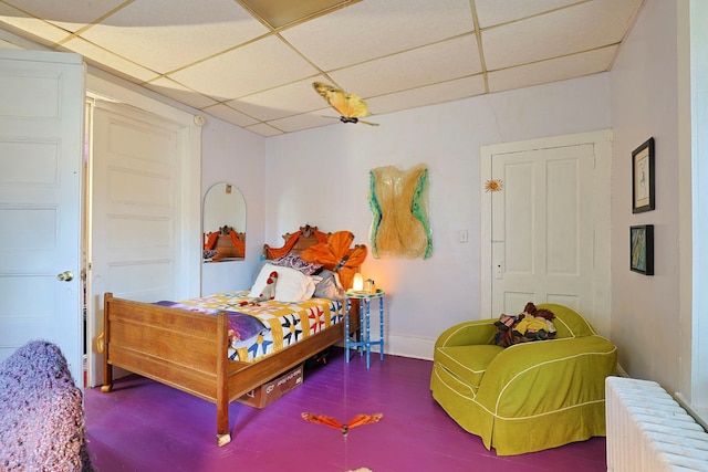 bedroom featuring radiator heating unit and a paneled ceiling