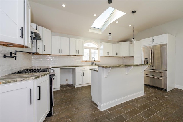 kitchen with vaulted ceiling with skylight, a center island, white cabinets, and stainless steel fridge with ice dispenser