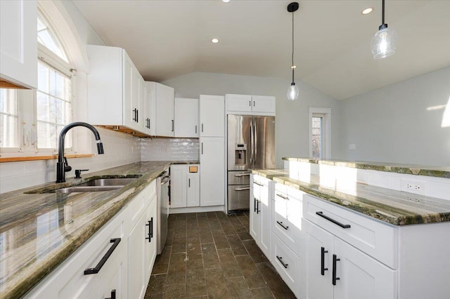 kitchen with a wealth of natural light, sink, stainless steel appliances, lofted ceiling, and white cabinets