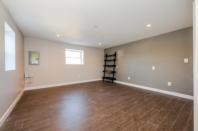 spare room featuring electric panel and dark wood-type flooring