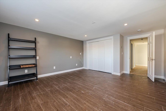 unfurnished bedroom featuring a closet and dark hardwood / wood-style floors