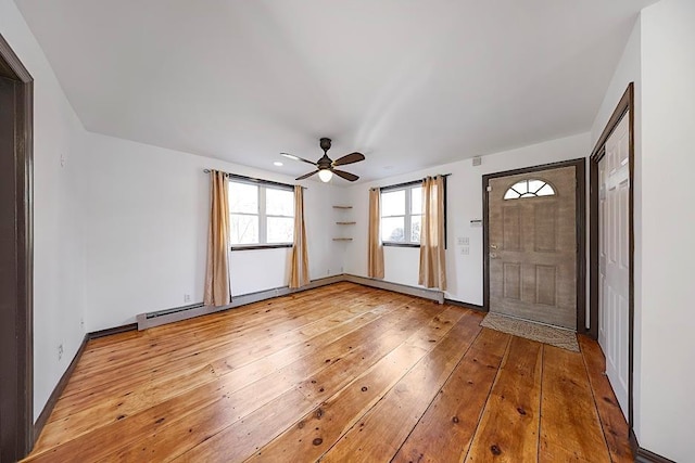 foyer entrance with baseboard heating, hardwood / wood-style floors, and ceiling fan