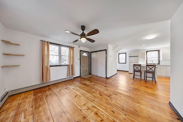 interior space with ceiling fan, light hardwood / wood-style floors, a healthy amount of sunlight, and sink