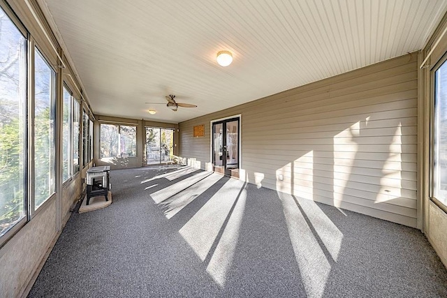 unfurnished sunroom with ceiling fan