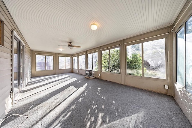 unfurnished sunroom featuring ceiling fan and a wealth of natural light