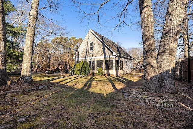 rear view of house with a yard and a sunroom