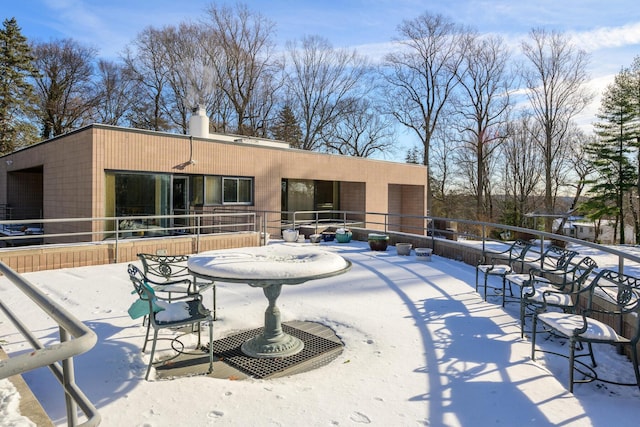 view of snow covered rear of property