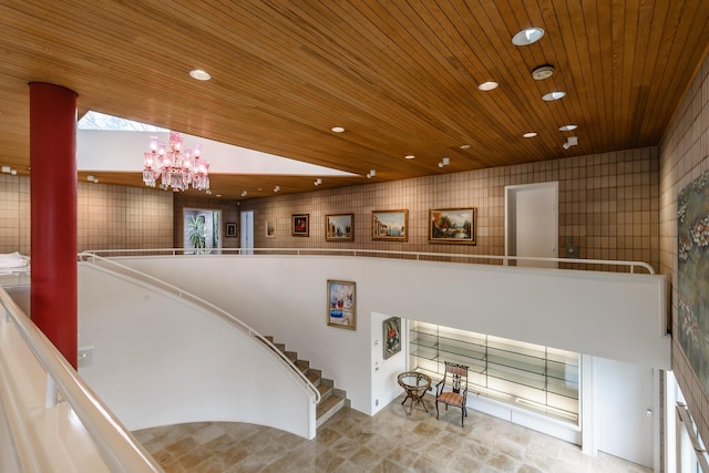 stairway with wood ceiling, vaulted ceiling, and an inviting chandelier