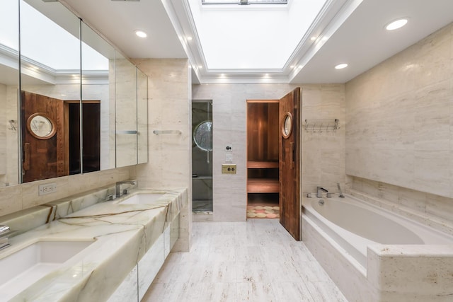 bathroom with tile walls, vanity, and tiled bath