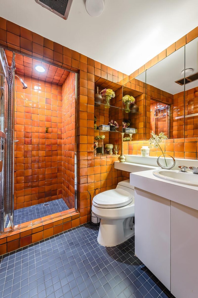 bathroom featuring vanity, toilet, tile patterned floors, and a shower with shower door