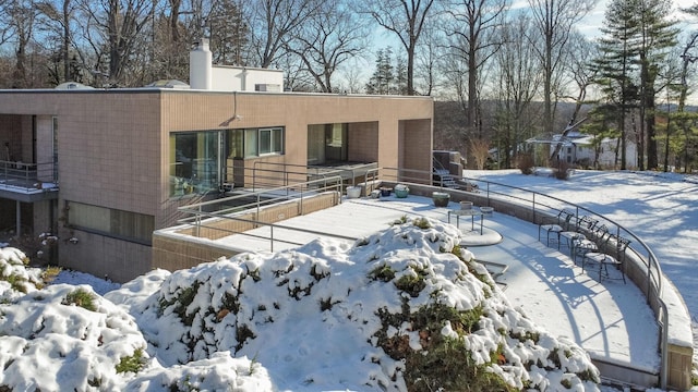 view of snow covered back of property