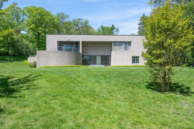 3 Paddock Ct, Old Westbury, NY 11568 - back of house featuring a yard, a balcony, and concrete block siding