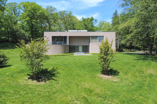 3 Paddock Ct, Old Westbury, NY 11568 - rear view of property with concrete block siding and a yard