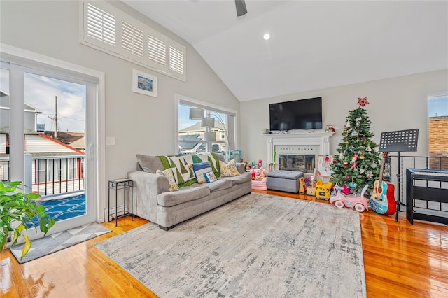 living room with hardwood / wood-style floors, vaulted ceiling, a wealth of natural light, and ceiling fan