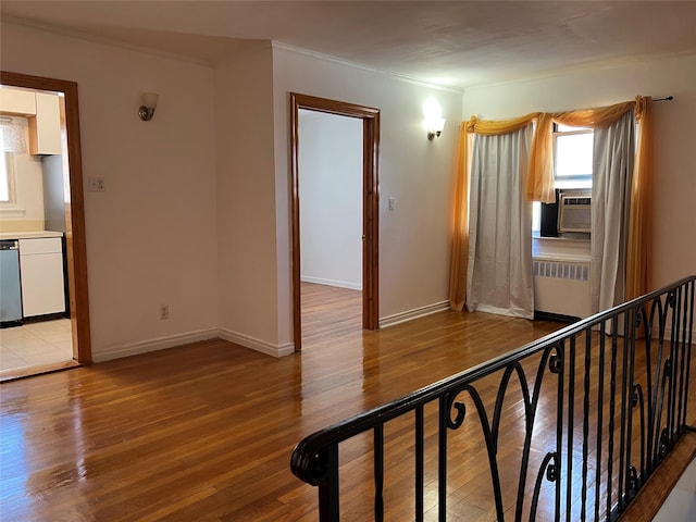 corridor featuring ornamental molding, light hardwood / wood-style flooring, radiator, and cooling unit