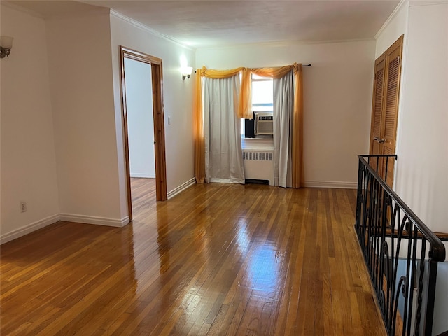 unfurnished room featuring hardwood / wood-style floors, cooling unit, crown molding, and radiator