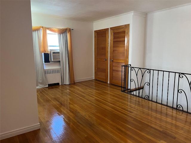 interior space featuring radiator heating unit, cooling unit, and wood-type flooring