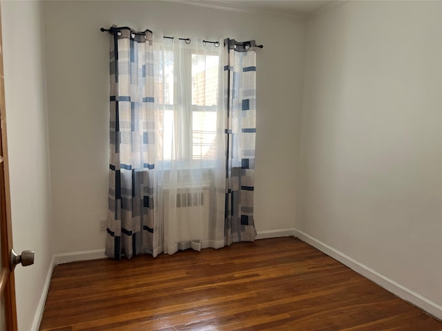 unfurnished room featuring dark hardwood / wood-style flooring and radiator