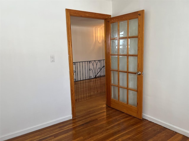 spare room featuring french doors and dark hardwood / wood-style floors