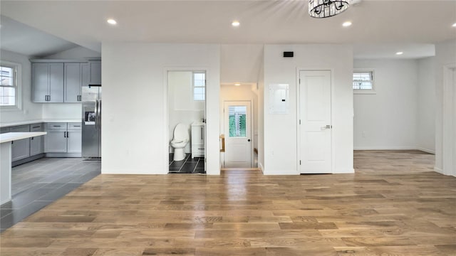 living room with electric panel, washer / clothes dryer, plenty of natural light, and light hardwood / wood-style flooring