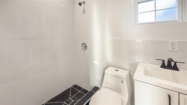 bathroom featuring tiled shower, vanity, and toilet