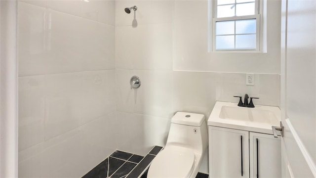 bathroom featuring vanity, toilet, and tiled shower