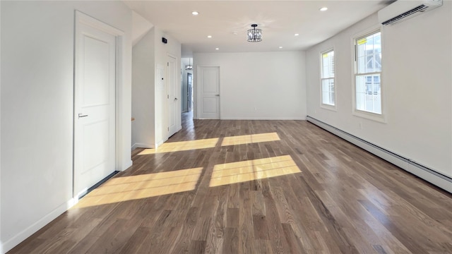 unfurnished room featuring an inviting chandelier, a baseboard heating unit, dark hardwood / wood-style flooring, and a wall mounted AC