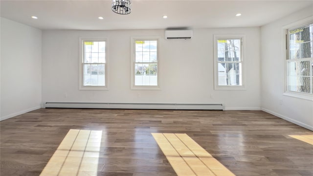 unfurnished room with baseboard heating, dark wood-type flooring, a wall mounted air conditioner, and a notable chandelier