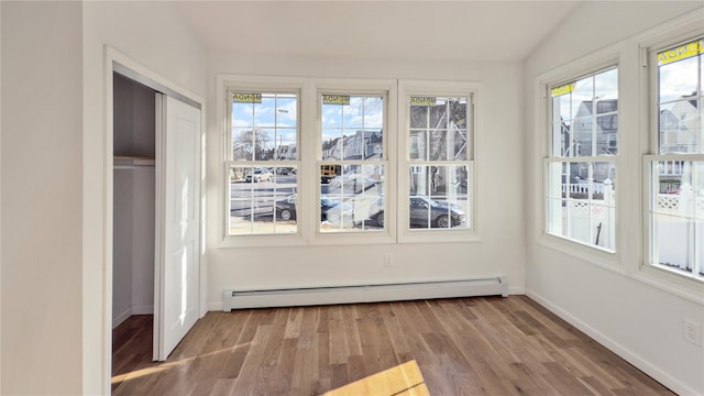 unfurnished sunroom featuring baseboard heating and lofted ceiling