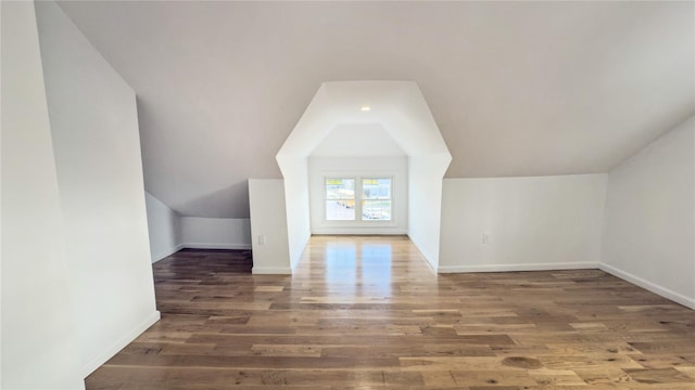 additional living space featuring dark hardwood / wood-style flooring and lofted ceiling