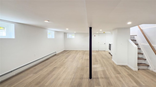 basement with baseboard heating and light wood-type flooring