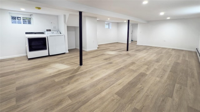 basement with light wood-type flooring and washing machine and clothes dryer